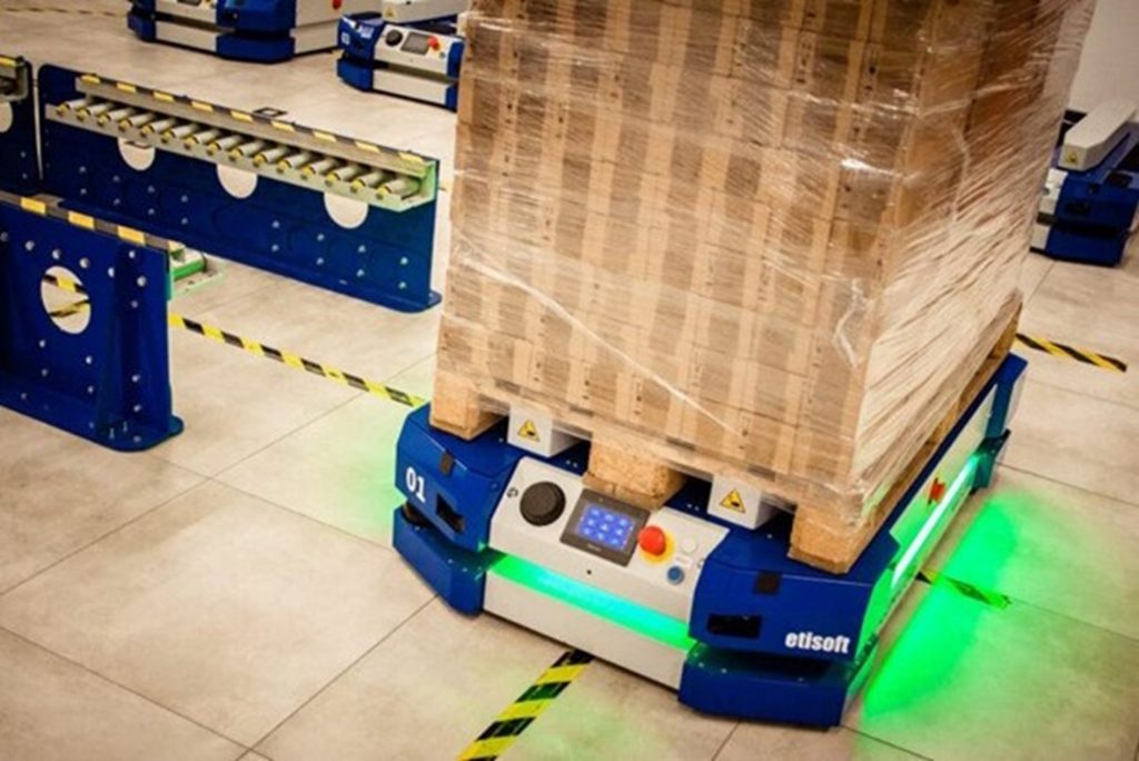 An AGV carrying a stack of pallets through a warehouse