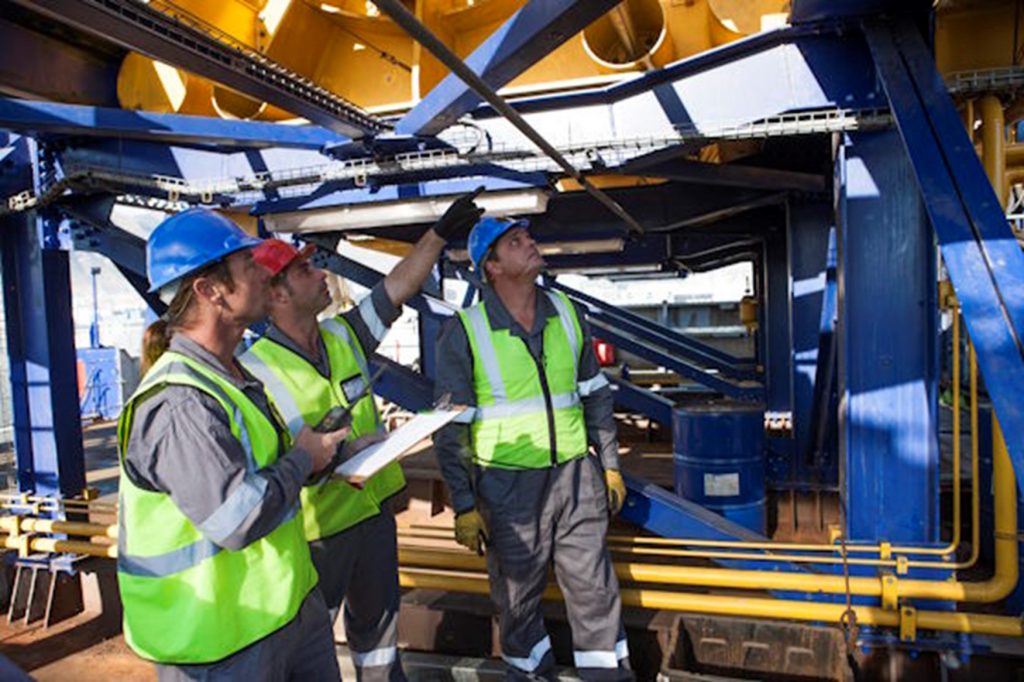 3 workers inspecting a crane