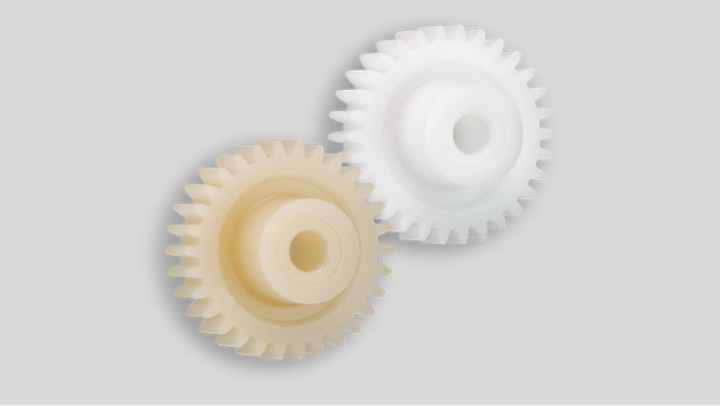 plastic gears connected to each other, a white one and a beige one