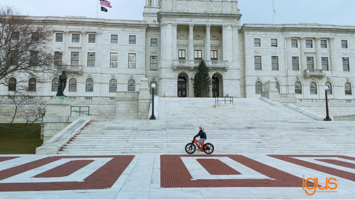person on a bike in front of a white building