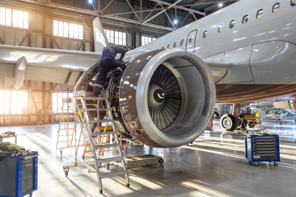 Mechanic specialist repairs the maintenance of engine of a passenger aircraft in a hangar.