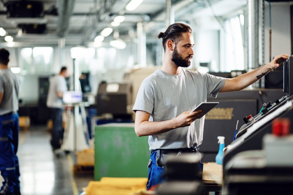 person holding a tabled in a factory