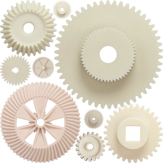 many off-white 3D-printed plastic gears in different designs