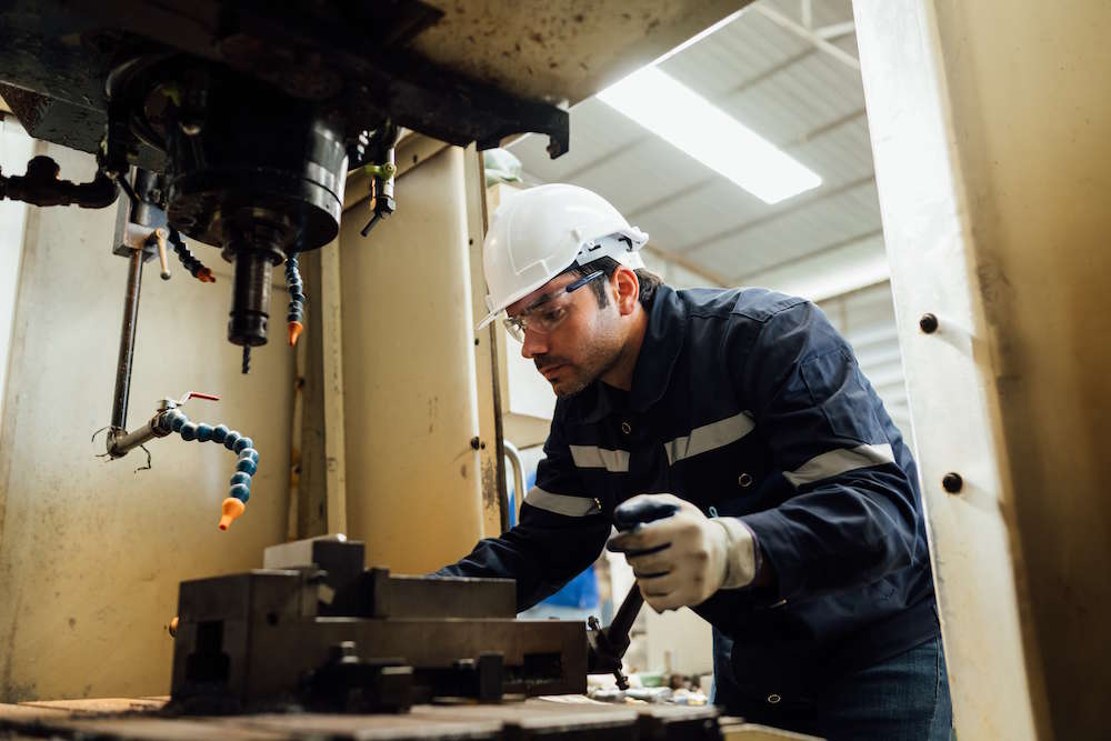 maintenance person doing maintenance on a machine tool